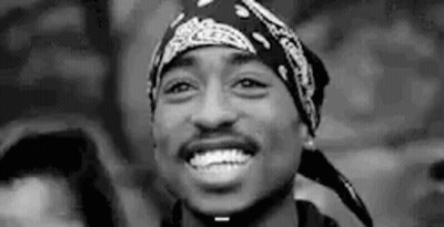 A Black And White Photo Of Tupac Shakur Wearing A Bandana . GIF