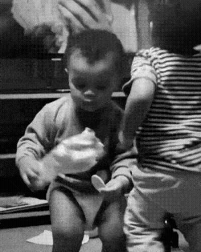 A Black And White Photo Of Two Babies Playing GIF