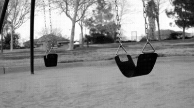 A Black And White Photo Of Two Empty Swings GIF