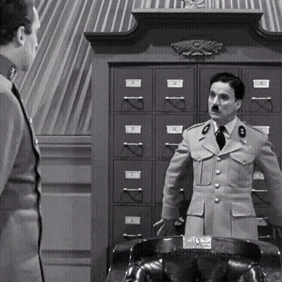 A Black And White Photo Of Two Men In Military Uniforms Standing Next To Each Other In Front Of A Filing Cabinet . GIF