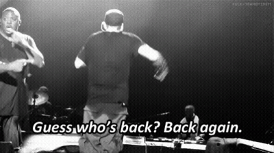 A Black And White Photo Of Two Men On A Stage With The Words Guess Who 'S Back Back Again GIF