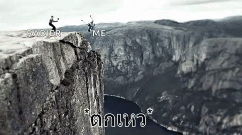 A Black And White Photo Of Two People Standing On Top Of A Mountain . GIF