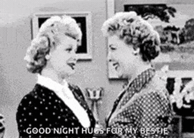 A Black And White Photo Of Two Women Hugging Each Other In A Room . GIF