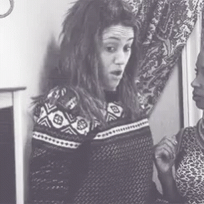 A Black And White Photo Of Two Women Standing Next To Each Other In A Room . GIF