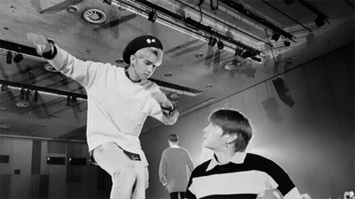 A Black And White Photo Of Two Young Men In A Dance Studio GIF