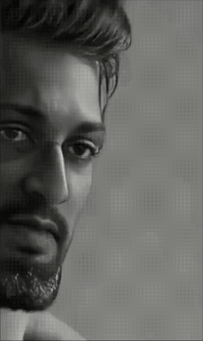 A Black And White Portrait Of A Man With A Beard Looking At The Camera . GIF
