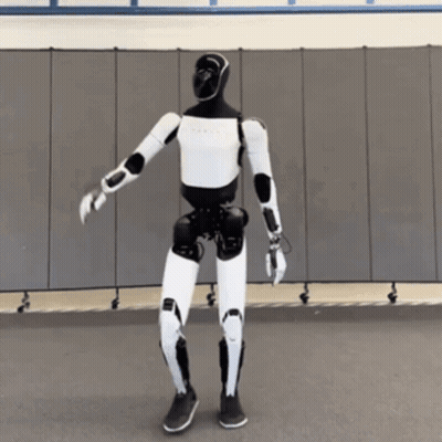A Black And White Robot Is Dancing In Front Of A Gray Wall GIF