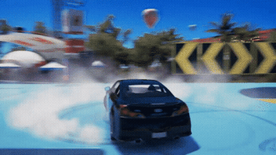 A Black Car Is Drifting In Front Of A Yellow Sign That Says Ko GIF