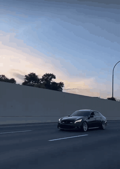 A Black Car Is Driving Down A Highway GIF
