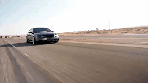 A Black Car Is Driving Down A Highway With A License Plate That Says Gnb GIF