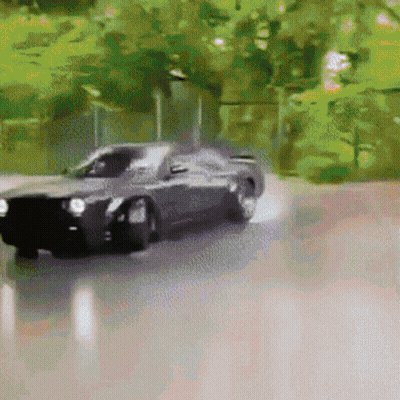 A Black Car Is Driving Down A Road With Trees In The Background And Smoke Coming Out Of The Tires . GIF
