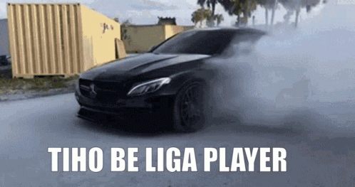 A Black Car Is Driving Down A Street With Smoke Coming Out Of It And The Words Tho Be Liga Player GIF