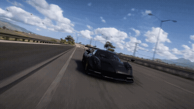 A Black Car Is Driving On A Highway With Mountains In The Background GIF
