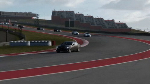 A Black Car Is Driving On A Race Track With A Delta Sign In The Background GIF