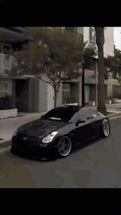 A Black Car Is Parked On The Side Of A Street GIF
