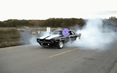 A Black Car With A Purple Ghost On The Back Is Drifting Down The Road GIF