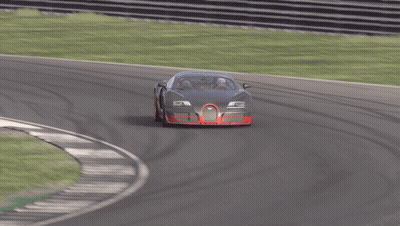 A Black Car With Red Wheels Is Driving On A Race Track GIF