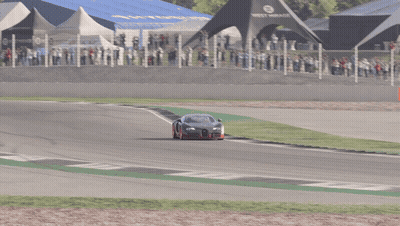 A Black Car With Red Wheels Is Driving On A Race Track GIF