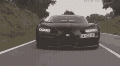 A Black Car With The License Plate W 022 Ja Is Driving Down A Road GIF