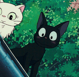 A Black Cat Standing Next To A White Cat In A Cartoon GIF