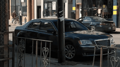 A Black Chrysler Car Is Parked On The Side Of The Street GIF