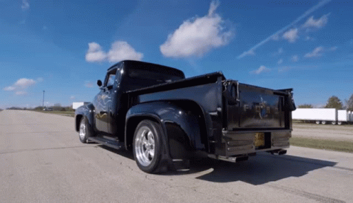 A Black Ford Truck Is Parked On The Road GIF