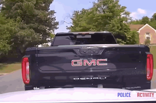 A Black Gmc Denali Truck Is Parked In Front Of A House GIF