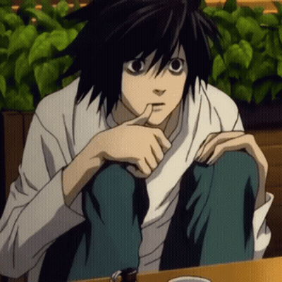 A Black Haired Anime Character Sitting At A Table With His Hand On His Chin GIF