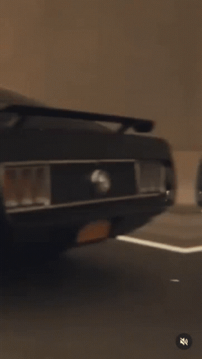 A Black Mustang Is Driving Down A Highway At Sunset . GIF
