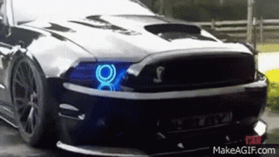 A Black Mustang With Blue Lights On The Headlights GIF