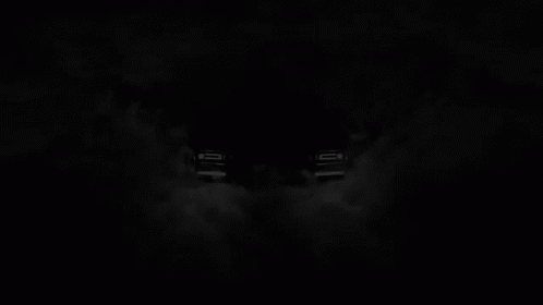 A Black Rolls Royce Is Surrounded By Smoke In A Dark Room GIF