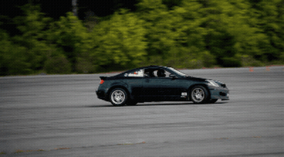 A Black Sports Car Is Driving Down A Road With A Sticker On The Side That Says ' Rs ' GIF