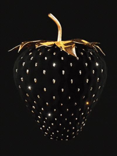 A Black Strawberry With Gold Spots And Leaves On A Black Background GIF