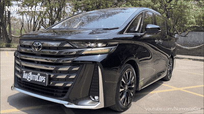 A Black Toyota Minivan Is Parked In A Parking Lot With Trees In The Background GIF