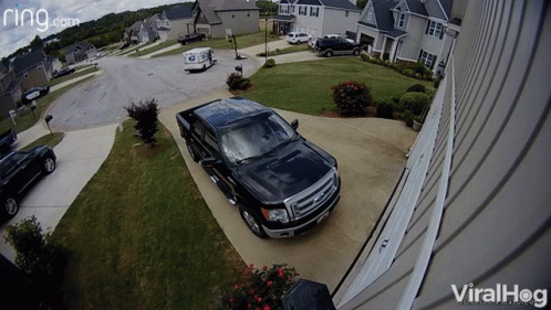 A Black Truck Is Parked In Front Of A House With A Ring.com Logo GIF