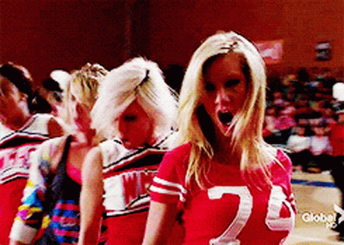 A Blonde Cheerleader Wearing A Red Shirt With The Number 2 On It GIF