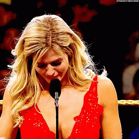 A Blonde Woman In A Red Dress Is Speaking Into A Microphone GIF