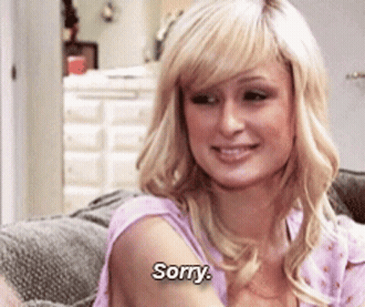 A Blonde Woman Is Sitting On A Couch And Saying Sorry GIF