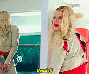 A Blonde Woman Is Standing In Front Of A Mirror And Says " Oopsie " GIF