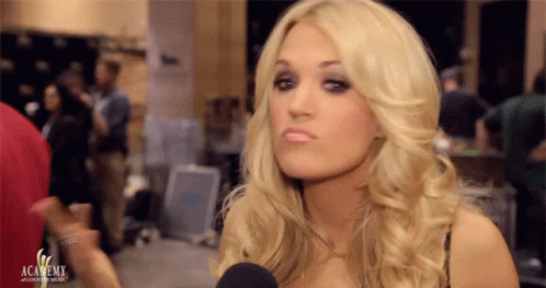 A Blonde Woman Is Talking Into A Microphone With The Academy Logo Visible In The Background GIF