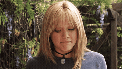 A Blonde Woman Wearing A Choker Necklace Looks Down GIF