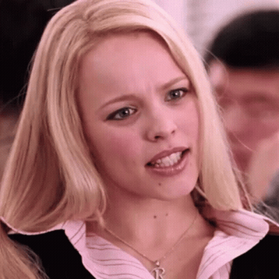 A Blonde Woman Wearing A Necklace With A Letter R On It GIF