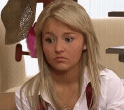 A Blonde Woman Wearing A White Shirt And A Red Tie Is Looking At The Camera . GIF