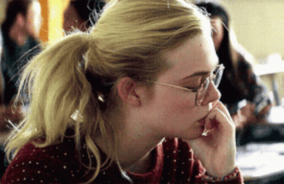 A Blonde Woman Wearing Glasses And A Ponytail Looks Down GIF