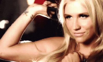 A Blonde Woman With A Tattoo On Her Wrist Is Holding A Bottle Of Water . GIF