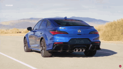 A Blue Acura Is Driving Down A Road GIF