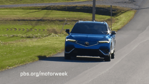 A Blue Acura Is Driving Down The Road GIF