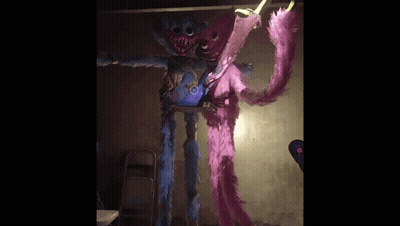 A Blue And Pink Stuffed Animal Are Standing Next To Each Other In A Room . GIF