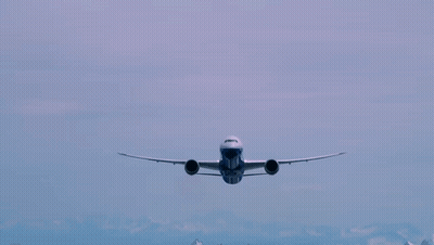 A Blue And White Airplane Flying In The Sky With The Number 777 On The Front GIF