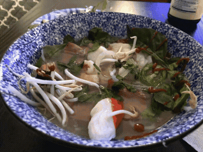 A Blue And White Bowl Filled With Noodles And Meat GIF